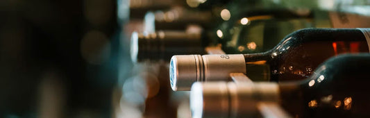 Close up of bottles on their side on a wine rack 