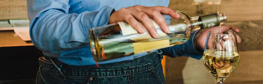 Sommelier pouring white wine into a wine glass