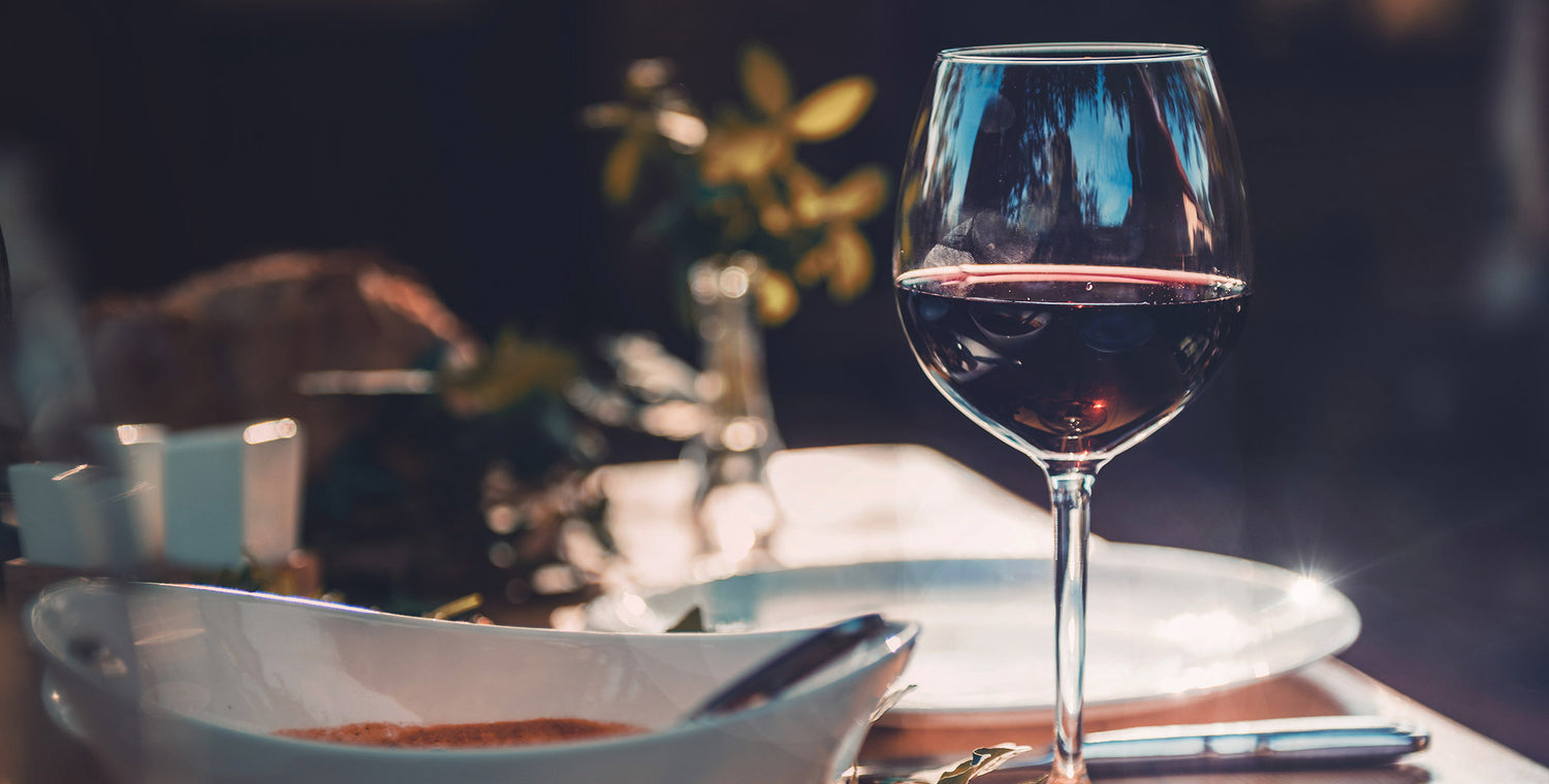 A glass of red wine on a dinner table
